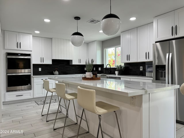 kitchen with white cabinetry, a center island, and hanging light fixtures