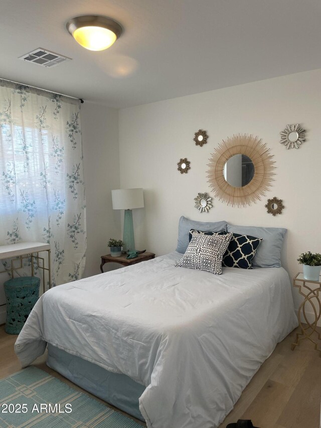 bedroom featuring visible vents and wood finished floors