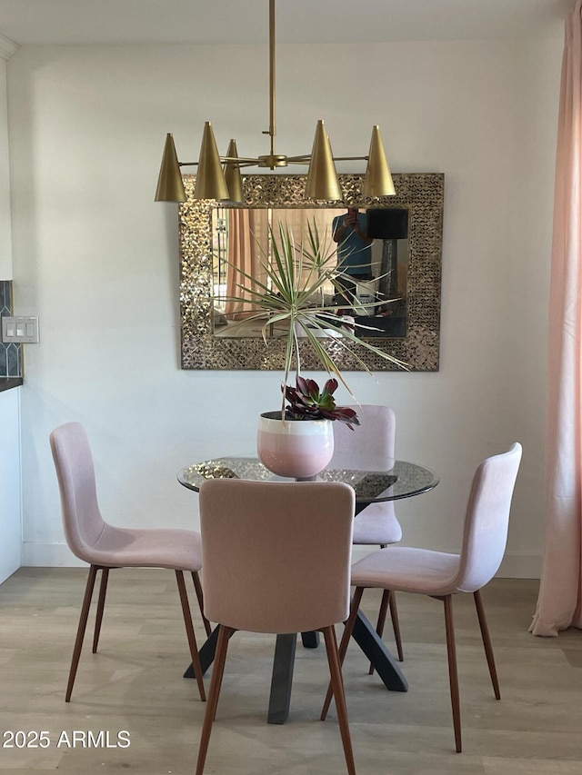 dining area with baseboards and light wood-style flooring