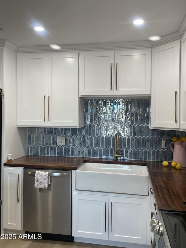 kitchen with white cabinetry, wooden counters, stainless steel appliances, and a sink