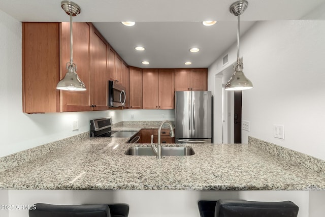 kitchen featuring sink, a kitchen breakfast bar, kitchen peninsula, and appliances with stainless steel finishes