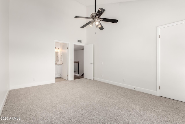 unfurnished bedroom with ceiling fan, light carpet, high vaulted ceiling, and ensuite bath