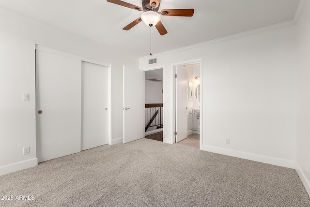 unfurnished bedroom with ceiling fan, connected bathroom, ornamental molding, light colored carpet, and a closet