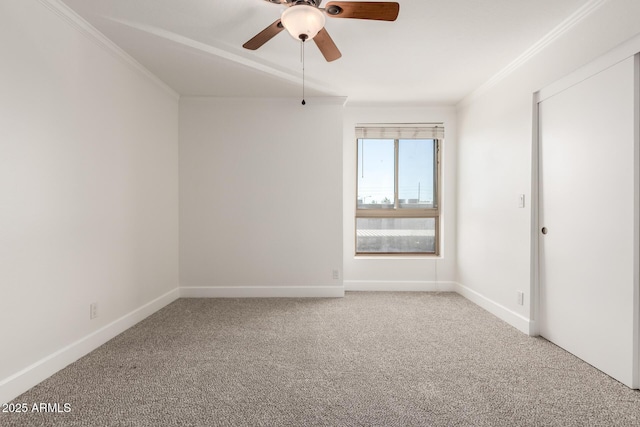 empty room with ceiling fan, ornamental molding, and carpet flooring