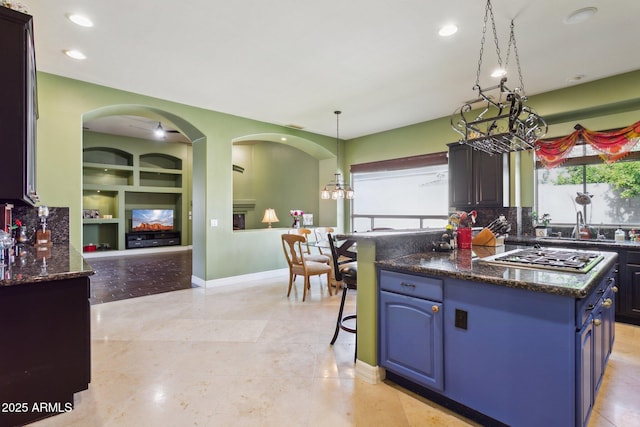 6428 W Eugie Ave, Glendale, AZ 85304 - kitchen featuring stainless steel gas stovetop, blue cabinets, a kitchen bar, a kitchen island, and built in features