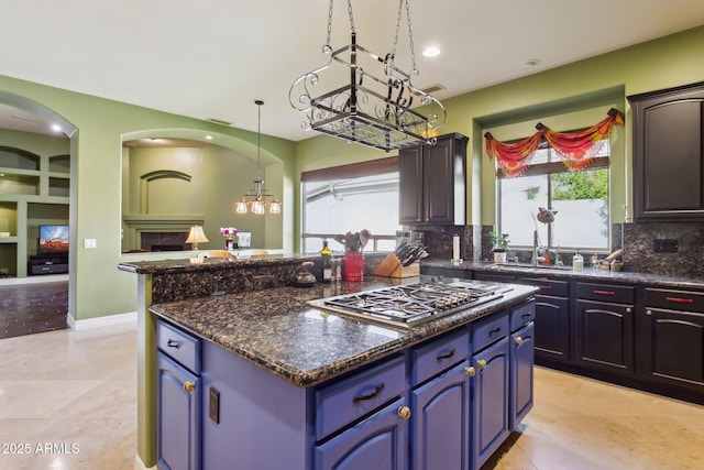 6428 W Eugie Ave, Glendale, AZ 85304 - kitchen with backsplash, a center island, stainless steel gas cooktop, a sink, and pendant lighting