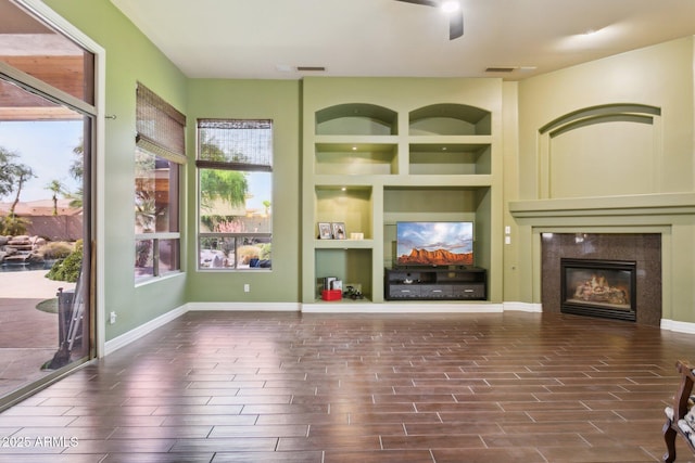 6428 W Eugie Ave, Glendale, AZ 85304 - unfurnished living room with built in shelves, wood finished floors, a fireplace, ceiling fan, and baseboards