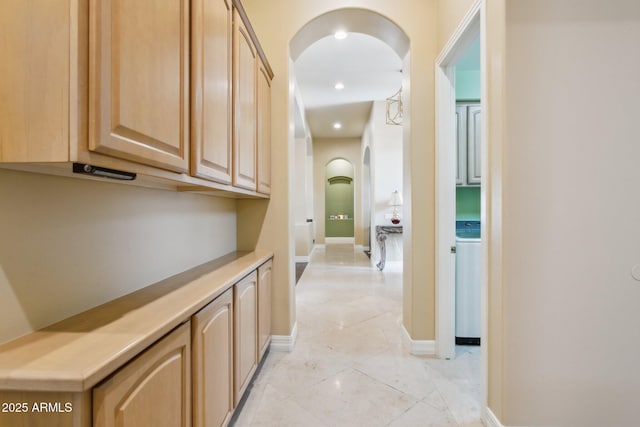 6428 W Eugie Ave, Glendale, AZ 85304 - corridor featuring arched walkways, washer / clothes dryer, baseboards, and light tile patterned floors