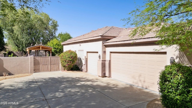 6428 W Eugie Ave, Glendale, AZ 85304 - view of home's exterior with driveway, stucco siding, a garage, a gate, and a tile roof