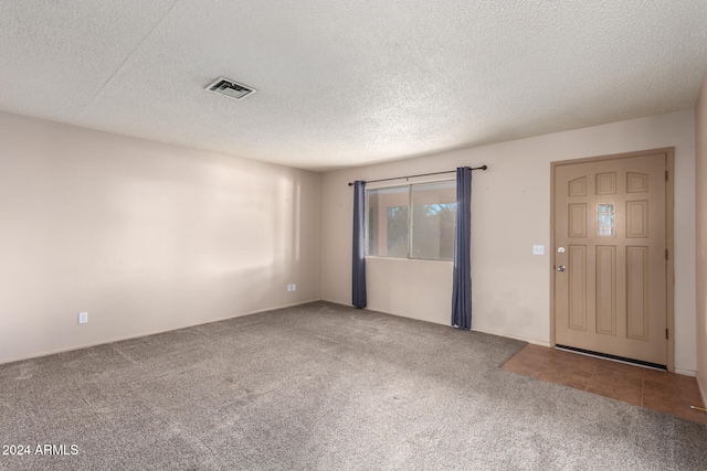 entrance foyer with a textured ceiling and carpet flooring