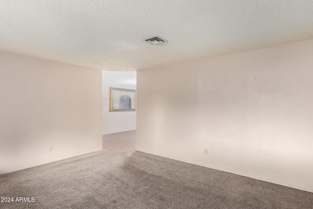 carpeted spare room featuring a textured ceiling