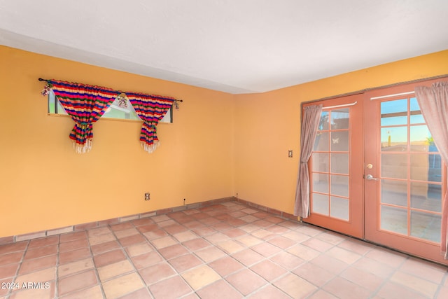 tiled empty room featuring french doors