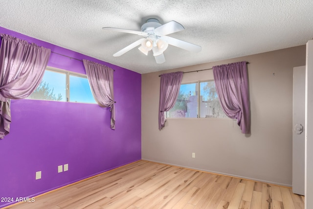 spare room featuring light hardwood / wood-style floors, a textured ceiling, and ceiling fan