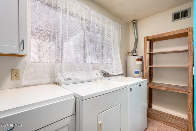 clothes washing area with independent washer and dryer, cabinets, light tile patterned floors, and water heater