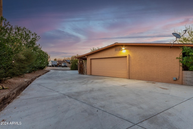 view of garage at dusk