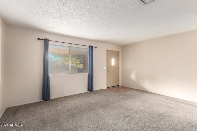 unfurnished room featuring carpet floors and a textured ceiling