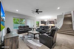 living area featuring recessed lighting, a ceiling fan, and stairs