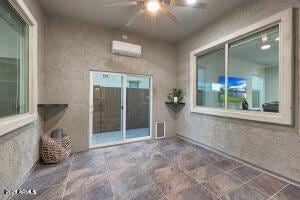 exterior space with a wall mounted air conditioner, a patio, and a ceiling fan