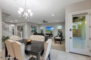 dining area with light tile patterned floors, recessed lighting, stairs, and ceiling fan with notable chandelier