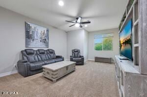 carpeted living area featuring baseboards and ceiling fan