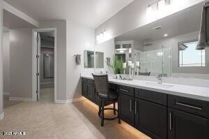 full bath with vanity, a stall shower, and baseboards