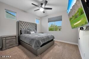 bedroom with ceiling fan, carpet flooring, and baseboards