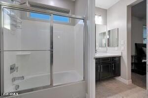 bathroom with bath / shower combo with glass door and vanity