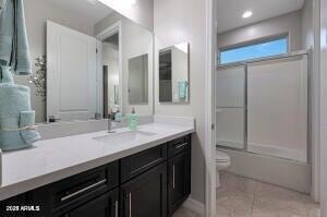 bathroom featuring washtub / shower combination, toilet, tile patterned flooring, and vanity