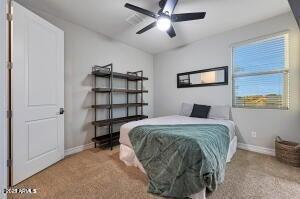 carpeted bedroom featuring baseboards and a ceiling fan