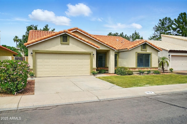 view of front of home featuring a garage, a tile roof, stucco siding, and driveway