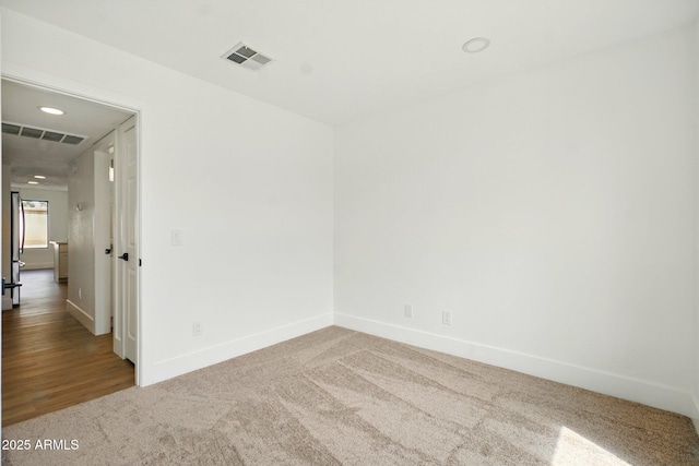 carpeted spare room with baseboards and visible vents