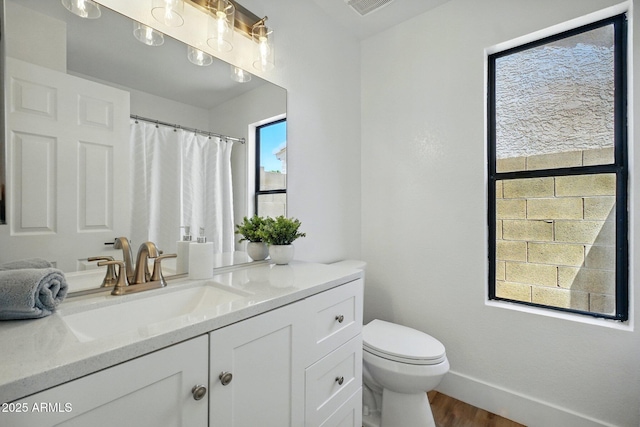 bathroom with wood finished floors, vanity, curtained shower, baseboards, and toilet