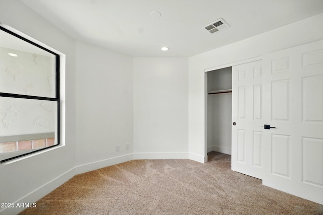 unfurnished bedroom featuring recessed lighting, visible vents, carpet floors, a closet, and baseboards