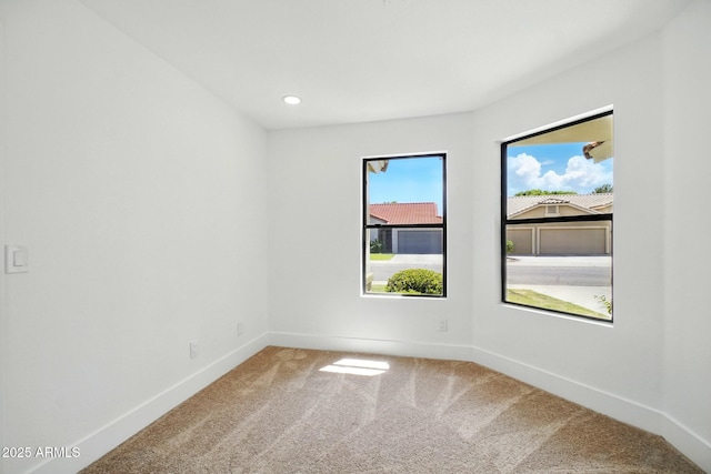 carpeted spare room featuring recessed lighting and baseboards