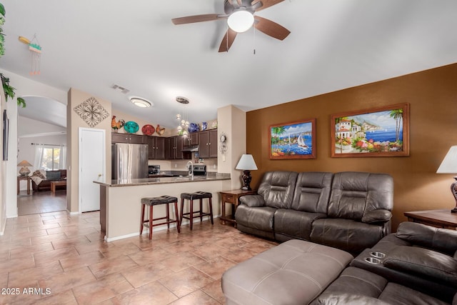 living room featuring vaulted ceiling, sink, and ceiling fan