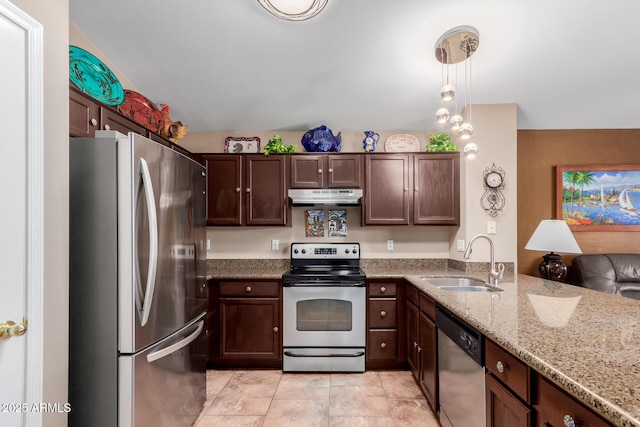 kitchen with sink, hanging light fixtures, dark brown cabinetry, stainless steel appliances, and light stone countertops