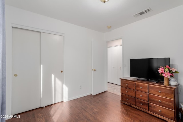 bedroom with wood-type flooring and a closet