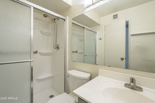 bathroom featuring toilet, a shower stall, visible vents, and vanity