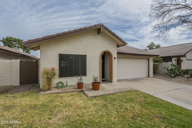 view of front facade with an attached garage, concrete driveway, a tiled roof, stucco siding, and a front yard