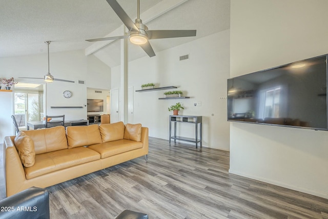 living area featuring visible vents, ceiling fan, wood finished floors, high vaulted ceiling, and beamed ceiling