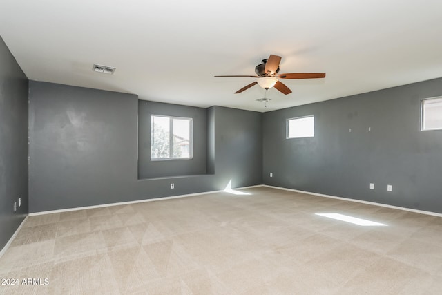 carpeted spare room featuring ceiling fan