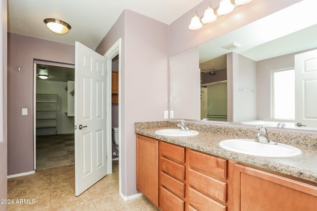 bathroom featuring tile patterned floors, vanity, toilet, and walk in shower