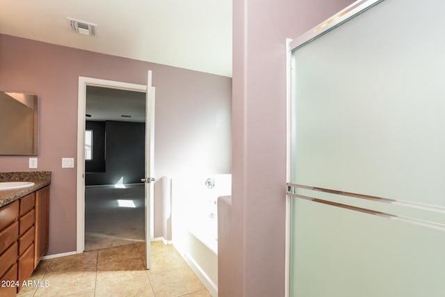 bathroom featuring tile patterned flooring, vanity, and shower with separate bathtub