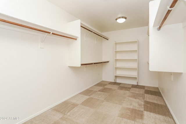 walk in closet featuring light carpet