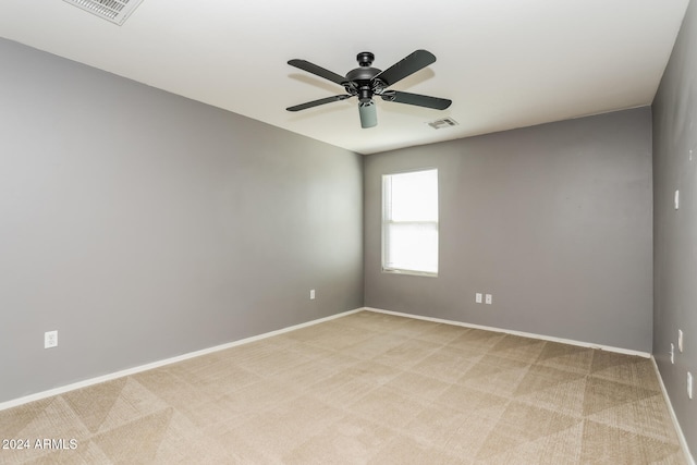 empty room featuring ceiling fan and light colored carpet