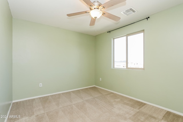 unfurnished room featuring light colored carpet and ceiling fan