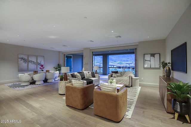 living area featuring light wood-style floors, recessed lighting, and baseboards