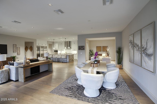 dining space featuring baseboards, light wood-style flooring, visible vents, and recessed lighting