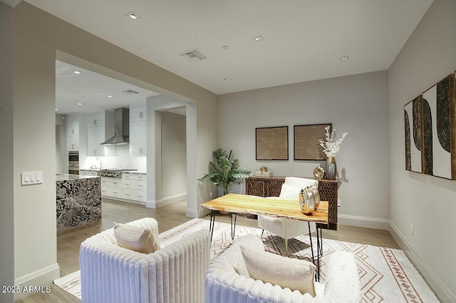 office space with light wood-style floors, visible vents, baseboards, and recessed lighting