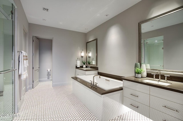 bathroom featuring two vanities, a garden tub, a sink, and a shower stall